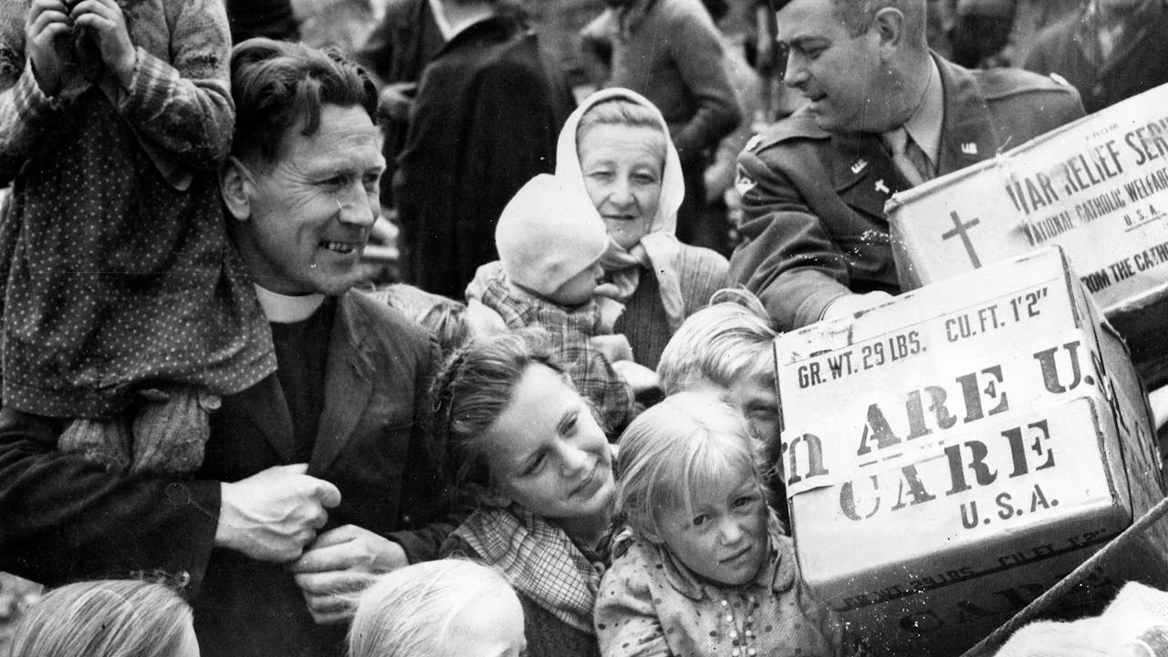 Historische zwart-witfoto: een groep mensen krijgt CARE-pakketten