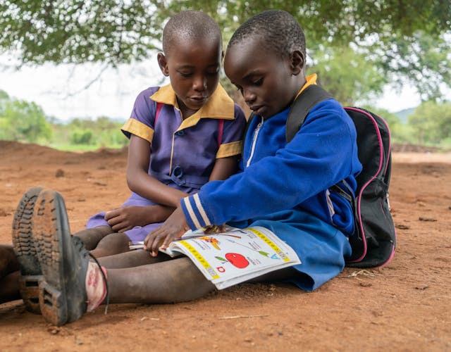 Twee kinderen uit Zimabwe die buiten aan het leren zijn