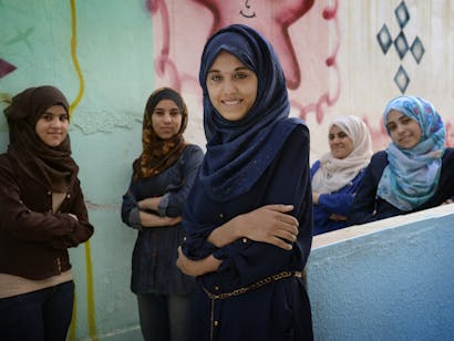 Een aantal meisjes met een hijab staan lachend voor de camera