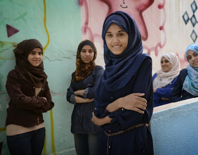 Een aantal meisjes met een hijab staan lachend voor de camera