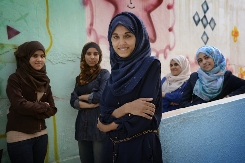 Een aantal meisjes met een hijab staan lachend voor de camera