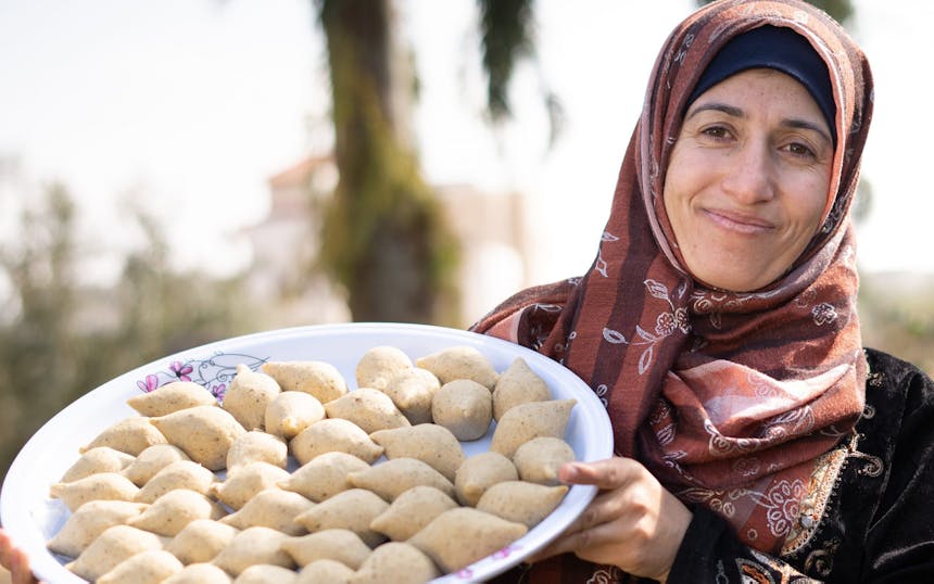Zakenvrouw Asma met haar specialiteit 'Kibbeh' (een traditionele Syrische gefrituurde snack van bulgur, tarwe, vlees en kruiden).