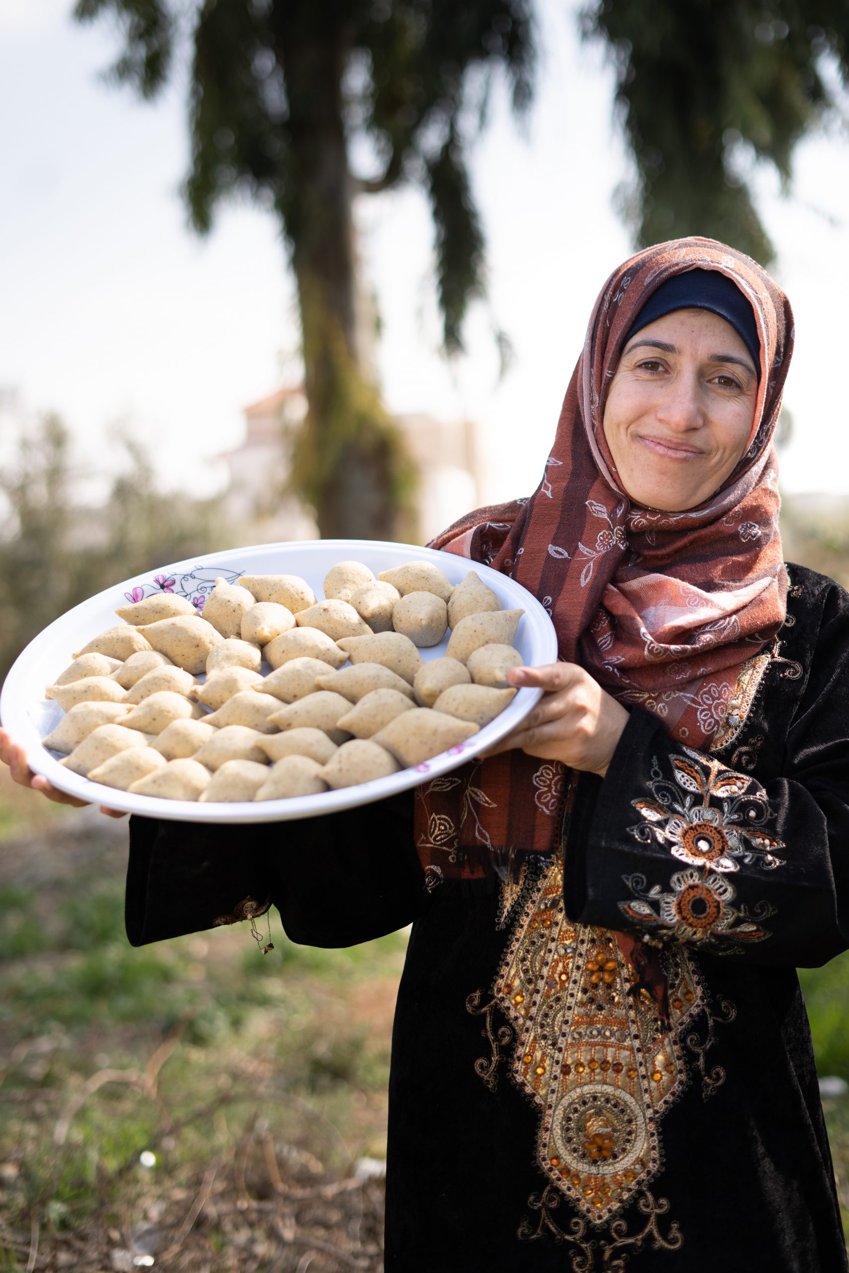 Zakenvrouw Asma met haar specialiteit 'Kibbeh' (een traditionele Syrische gefrituurde snack van bulgur, tarwe, vlees en kruiden).