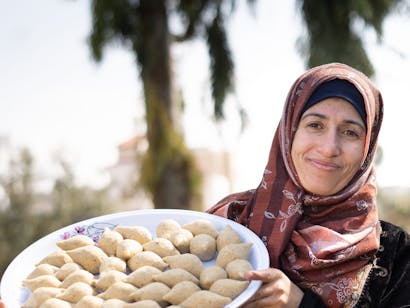 Zakenvrouw Asma met haar specialiteit 'Kibbeh' (een traditionele Syrische gefrituurde snack van bulgur, tarwe, vlees en kruiden).