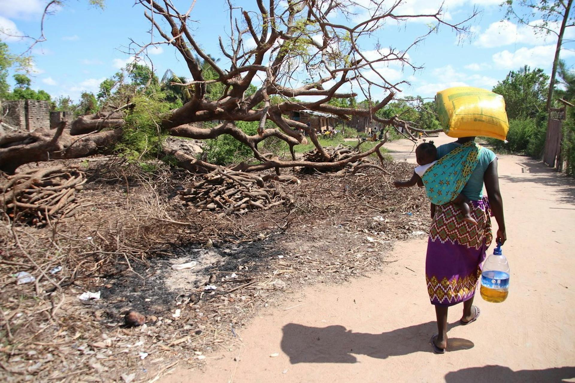 Vrouw met kind lopend in Mozambique na de cycloon Idai