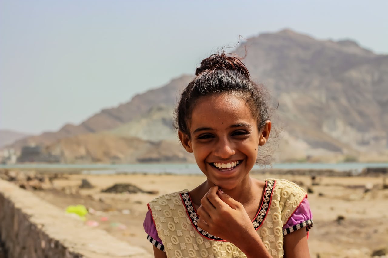 Amaal een 10 jarig meisje gevlucht uit Jemen hier lachend met bergen op de achtergrond