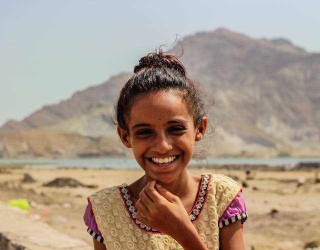 Amaal een 10 jarig meisje gevlucht uit Jemen hier lachend met bergen op de achtergrond