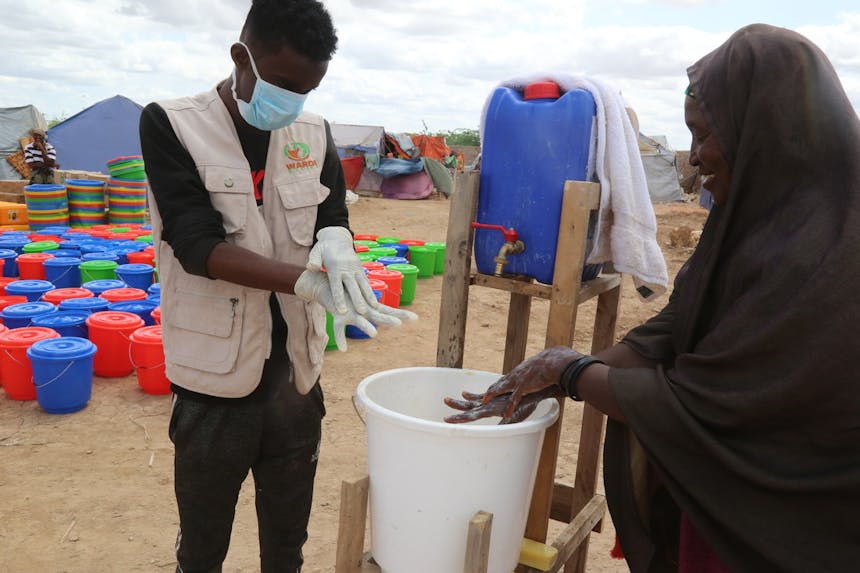 Vrouw krijgt instructies over handen wassen in Beletweyne, Somalie