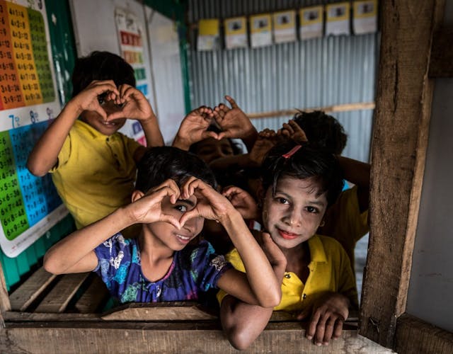 kinderen maken met hun handen hartjes in Bangladesh in een vluchtelingenkamp