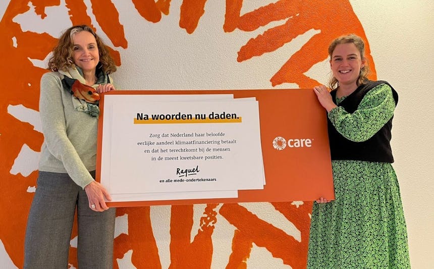 Reintje van Haeringen en Rosa van Driel van CARE Nederland houden het bord vast dat gericht is aan de Tweede Kamer